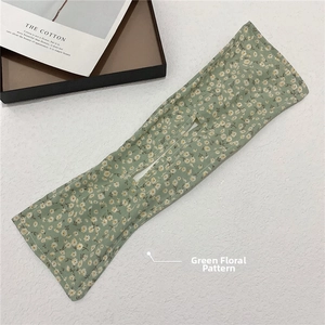 Detailed view of a green floral deft bun maker tool with white daisy print fabric