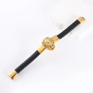 Close-up of black braided leather bracelet with golden lion head charm and metal clasp