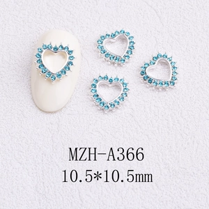 Close-up of 10.5mm hollow heart nail charm with lake blue rhinestones on a white nail model