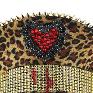 Dettaglio cappello da marinaio leopardato con borchie dorate e cuore di strass rossi
