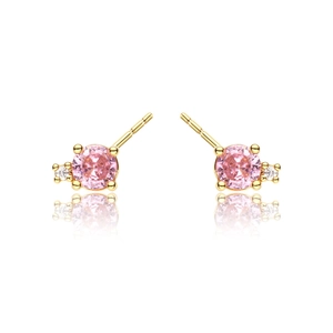 Macro detail of gold earrings featuring round pink gemstone and small clear side diamond