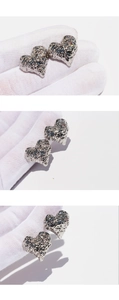 Detailed macro view of silver heart earrings with unique metallic wrinkled texture