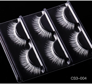 Detailed close-up of pure white false eyelashes with dense fibers on black background