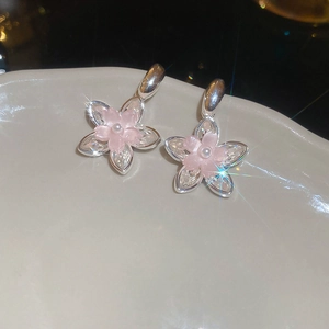 Détail de boucles d'oreilles vintage cœur et fleur avec pétales roses et perles