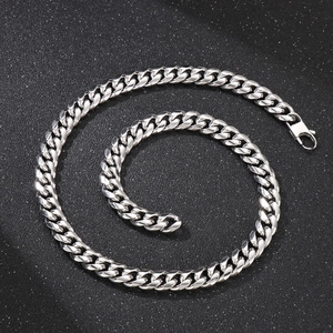 Macro shot of silver stainless steel curb chain with secure lobster clasp on black background