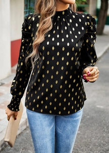 Detail view of black puff sleeve blouse with gold polka dots and pleated cuffs