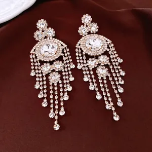 Vintage gold tassel earrings with shimmering crystals on dark satin background