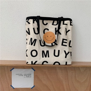 Detailansicht der Canvas-Einkaufstasche mit Buchstaben-Print und gelbem Smiley-Gesicht