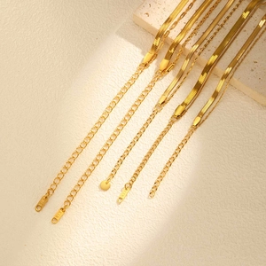 Detailed macro view of gold snake chain necklaces with lobster clasps and K18 tags