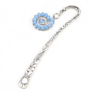 Detail of vintage silver bookmark with sun star carvings and spiral blue beaded charm
