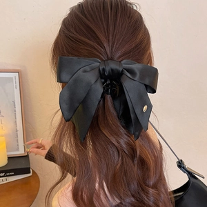 Elegant black satin double bow hair claw clip worn by model for office and daily style