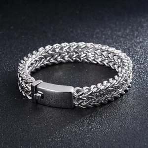 Detail of chunky stainless steel curb chain with braided texture and secure box clasp
