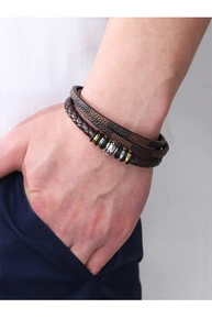 Detail of men's multilayer braided leather bracelet with silver and gold metal sliders