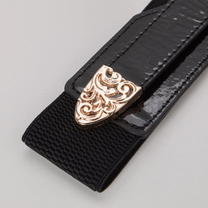Detail showing vintage gold hollow flower metal buckle on black elastic waist belt for women