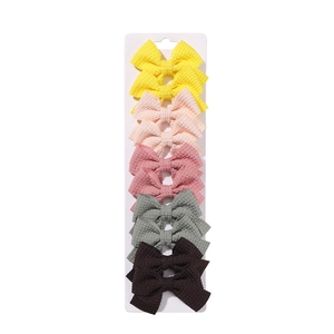 Set of 10 handmade fabric bow hair clips in pastel colors on white display card