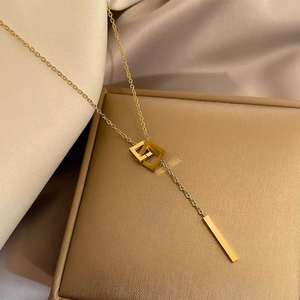 Minimalist gold titanium double interlocking square pendant necklace on jewelry box