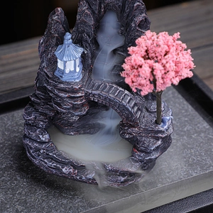 Artistic backflow incense burner with mountain landscape and pink cherry blossom tree