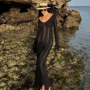 Detail of black ribbed knit dress with deep U-neck and sheer vertical stripe texture