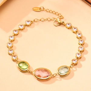 Close-up of gold-plated anklet with pink and green crystals and S925 silver tag