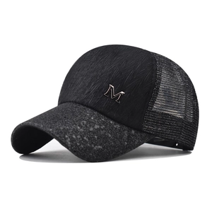 Detail of black sequin lace cap with metal M logo and breathable mesh texture