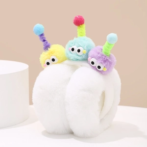 Detail of plush winter earmuffs with three colorful cartoon monster dolls on top