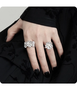 Detailed view of silver flower rings with pearls and sparkling crystals on hand