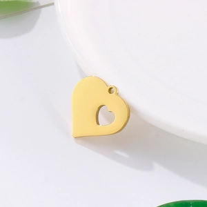 Gold hollow heart pendant made of stainless steel displayed on a white decorative plate