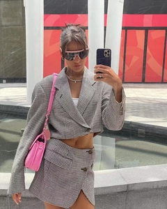 Détails du blazer et de la jupe à pied-de-poule avec un sac rose pour un look tendance