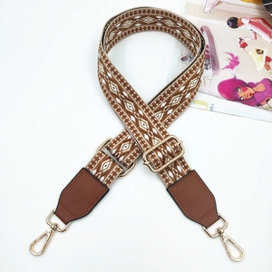 Close-up of 3.8cm wide jacquard bag strap with geometric patterns and gold metal hooks