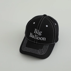 Detail view of black kids' baseball cap with white contrast stitching and embroidery