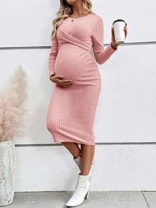 Pink ribbed knit maternity midi dress featuring a twist-front chest design and long sleeves