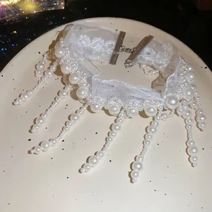 Elegant white lace choker necklace with pearl fringe tassels on ceramic tray