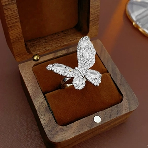 Detail of silver butterfly ring with sparkling zircons inside a luxury wooden jewelry box