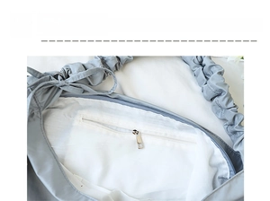 Detail view of the light grey shoulder bag interior with a white lining and zipper pocket