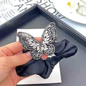 Macro shot of elegant butterfly hair clip with sparkling crystals on silk band