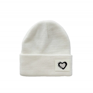 Close-up of white ribbed knit beanie with heart patch and My World text embroidery