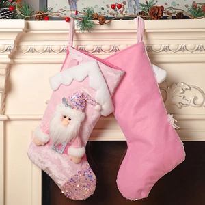 Pink sequin Santa Claus Christmas stockings hanging on a white festive fireplace
