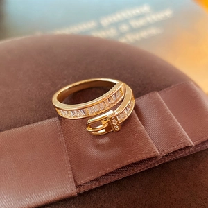 Detailed close-up of gold belt buckle ring with pavé zircons on brown velvet ribbon