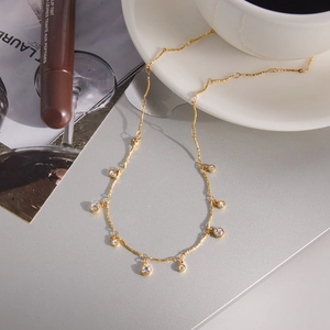 Detail van de 18K goudstalen ketting met ronde kristallen op een koffiekopje