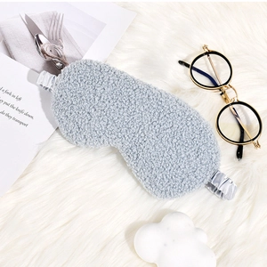Detail of light gray plush sleep mask with soft teddy fleece texture on white fur