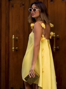 Détail de la robe nuisette en satin jaune avec dos nu et accents floraux sur les bretelles