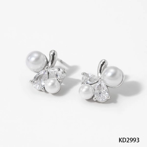 Détail de boucles d'oreilles argentées avec perles blanches et zircons cubiques brillants