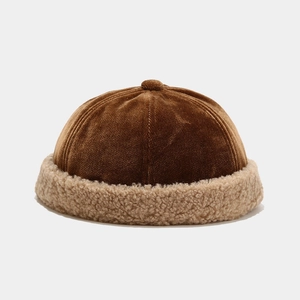 Detail of winter brimless cap featuring brown velvet texture and beige sherpa fleece trim