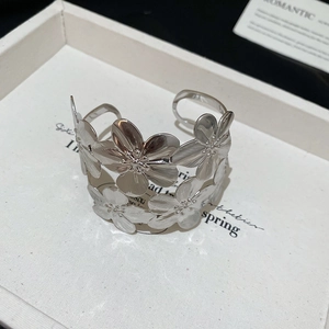 Detail of silver floral open cuff bracelet with matte textured petals and 45-degree angle