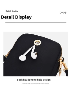Close-up of small black canvas crossbody bag featuring a functional back headphone jack hole