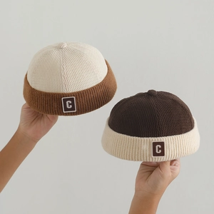 Detailed texture of baby corduroy docker hat with vintage letter C patch and roll-up brim