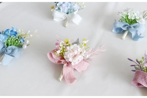 Close-up of handmade artificial flower boutonniere with elegant ribbon and pearl accents