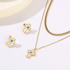 Detailed view of gold cross jewelry set with double necklaces and evil eye shell inlay
