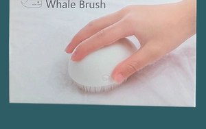 Close-up of whale-shaped laundry brush with soft bristles for delicate fabric cleaning