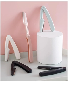 Foldable safety eyebrow razors in multiple colors on minimalist display stands